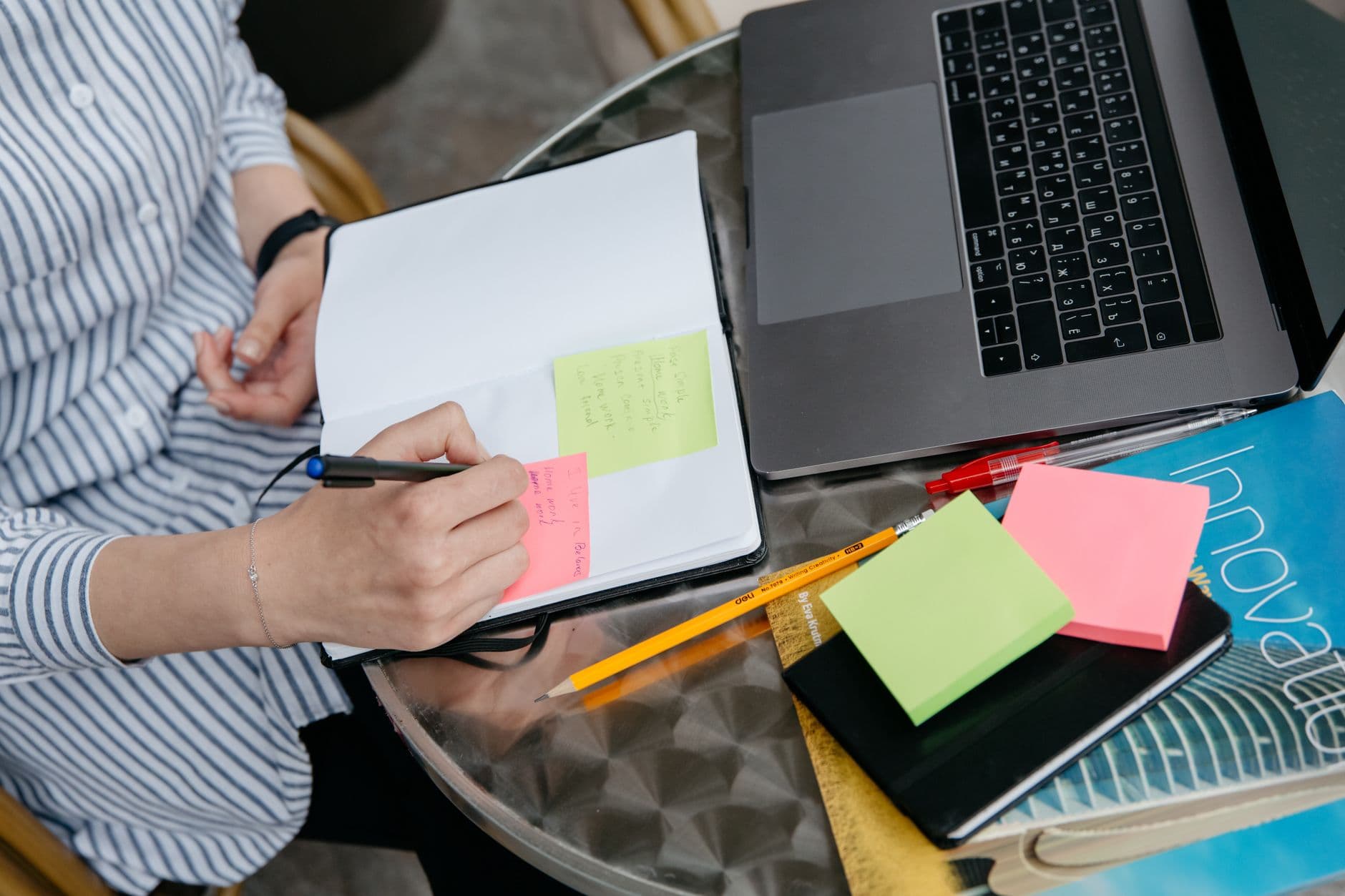 Qualitative researcher organizing interview transcript notes and coding themes on a laptop for NVivo thematic analysis