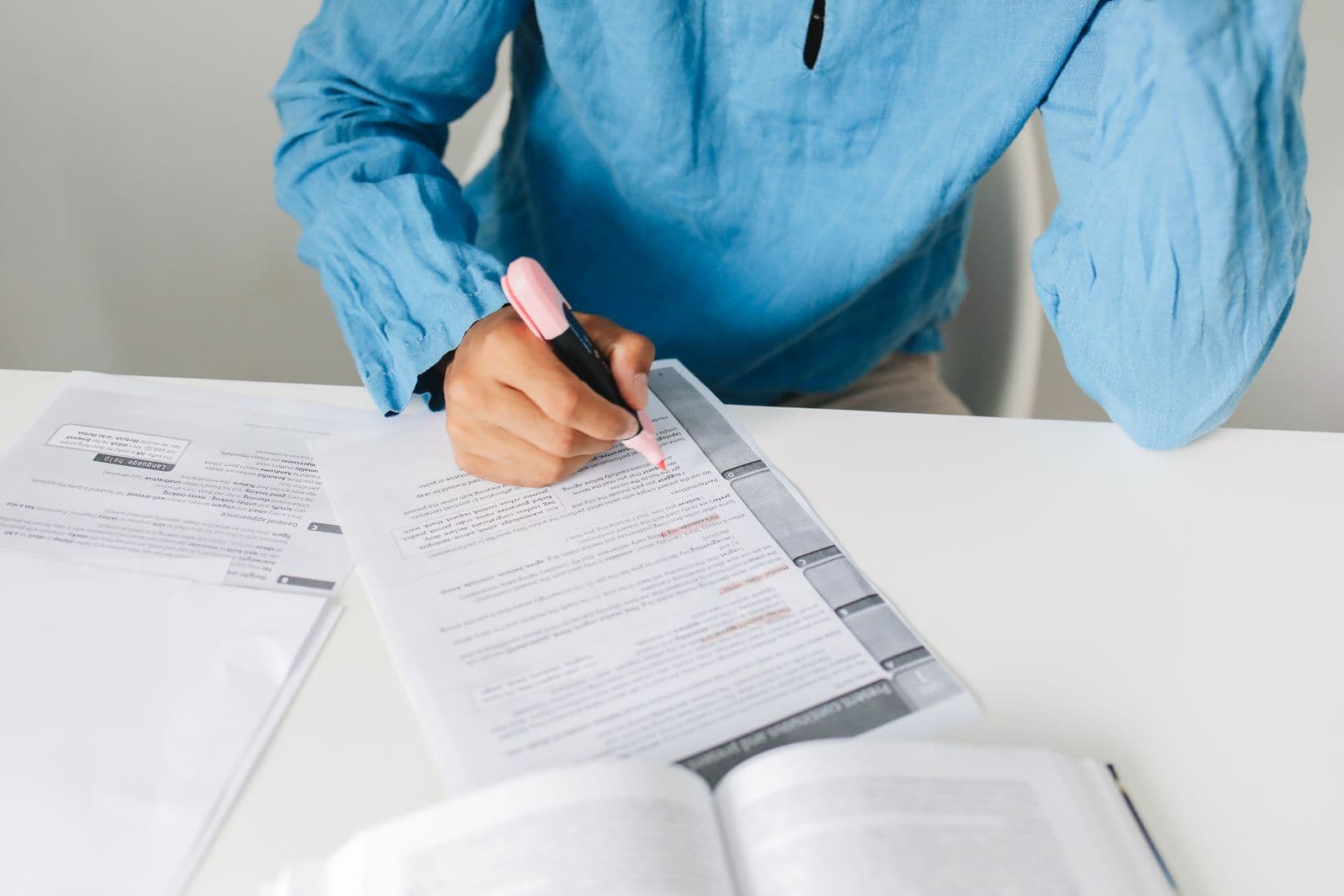 A researcher highlighting passages in printed documents at a desk, the first pass of qualitative content analysis